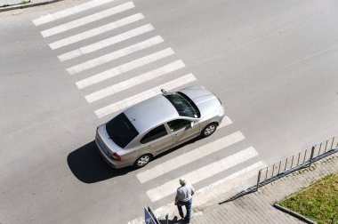 Yaya geçidi. Üst Manzara. İvano-Frankivsk. Ukrayna-23.05.2017. Bir adam caddeyi geçmeye başlıyor. Bir araba yaya geçidinde..