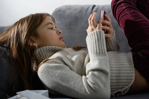 Het Jonge Meisje Kijkt Naar Het Scherm Van Een Smartphone — Stockfoto