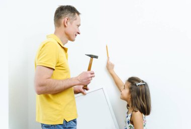 Baba ve kızı resmin nerede asılacağına karar veriyorlar..