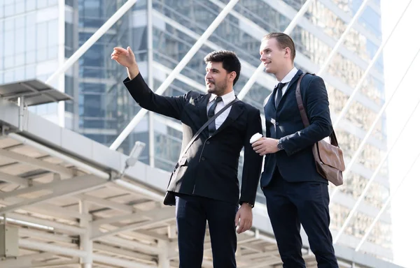 Business people talking. Two young business man talking to each other while walking outdoors