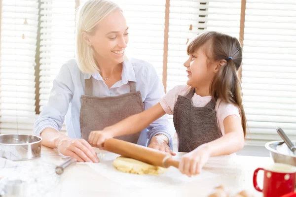 かわいい女の子と彼女の母親は 自宅の台所で混練生地を焼きます 幸せな家族や人々 の概念 母の日 — ストック写真