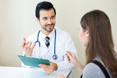 Erkek doktor kadın hastasını klinik tanı açıklama gülümseyerek. Sağlık, tıbbi tedavi ve sigorta kavramı.