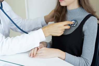 Closeup erkek doktor kontrol hasta hastanede ofisinde stetoskop kullanarak. Sağlık, tıbbi tedavi ve sigorta kavramı.