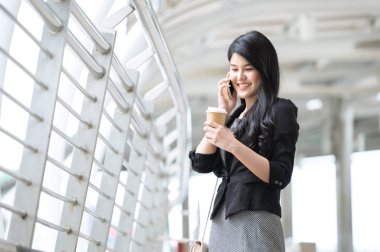 Akıllı telefon üzerinde street yürüyüş konuşurken iş Asyalı kadın.