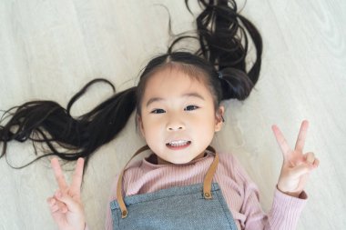 Dost arıyorum zafer hareketi her iki el ile gösterilen ile yerde yatarken şirin güzel bir kız. V işareti