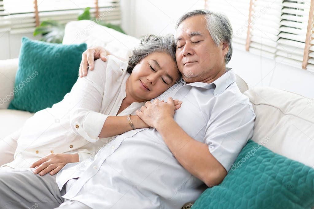 Senior couple relaxing sleeping together on sofa in living room at home. Relax and Lifestyle Concept.