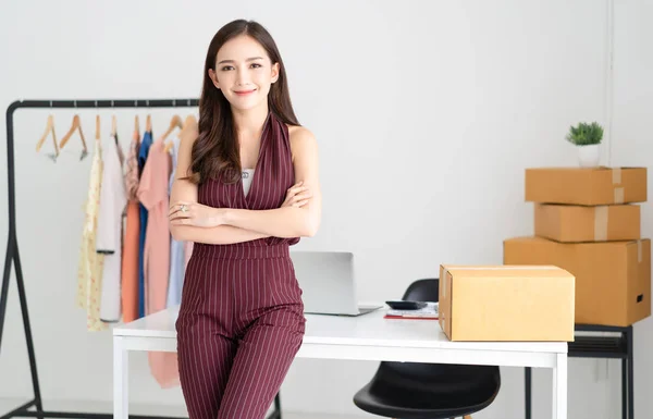 Young Asian casual woman working small business online  standing with arms crossed and looking at camera and smiling at home office. Startup Small business owner,Online selling, e-commerce,Freelance Startup Home office