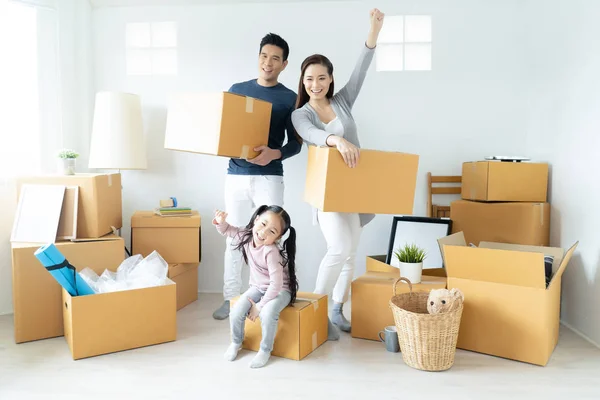 Happy young Asian family moves the boxes to a new home. Moving Concept.