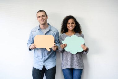 Konuşma kabarcıklar simgeler oturma odasında tutan karışık yarış çift