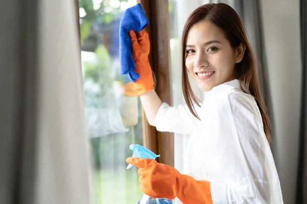 Vacker ung asiatisk kvinna bär skyddande handskar rengöring W — Stockfoto
