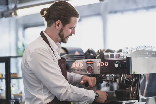 Yakışıklı hipster barista müşteri için kahve fincan hazırlanıyor