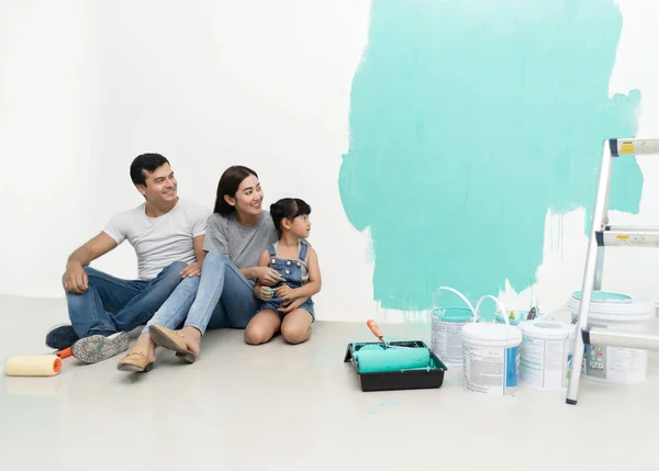 Happy multiethnic family renovating their new home, they are sit