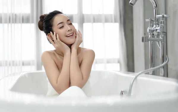 Belle jeune femme asiatique relaxant assis dans la baignoire dans — Photo