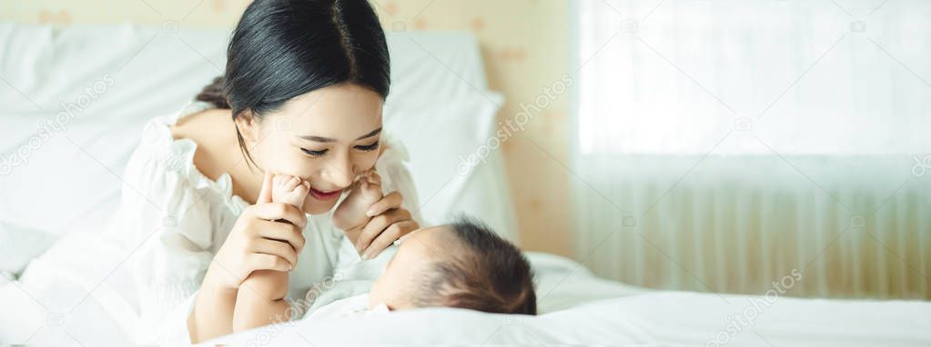 Panoramic banner image of side view of a young Asian mother hand