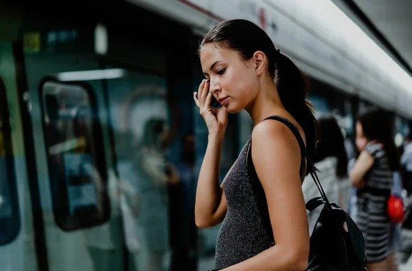 Portrét mladé dívky, jak mluví na telefonu, zatímco čeká na — Stock fotografie