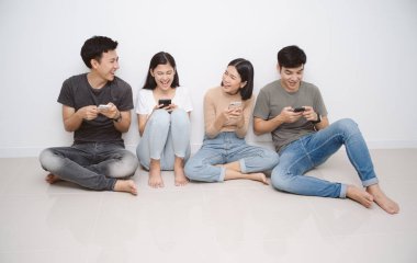 Akıllı cep telefonları kullanarak katta oturan arkadaş grubu.
