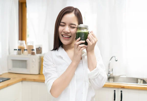 Улыбающаяся счастливая молодая азиатка пьет свежий зеленый детоксикатор v — стоковое фото