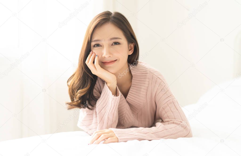 Portrait of young Asian woman smiling friendly and looking at ca