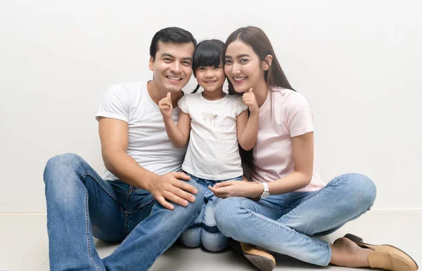 Portrait de famille multiethnique heureuse assise sur le sol avec un enfant — Photo