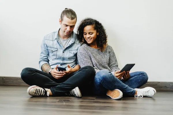 Sonriendo joven pareja multiétnica utilizando tableta digital juntos un — Foto de Stock