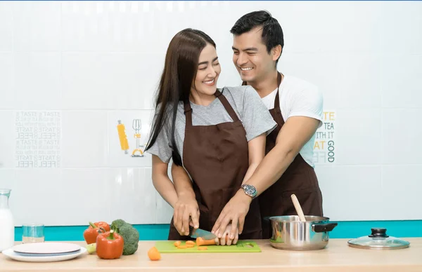 ロマンチックなカップルは台所で料理しています。若い幸せな笑顔のクーペ — ストック写真