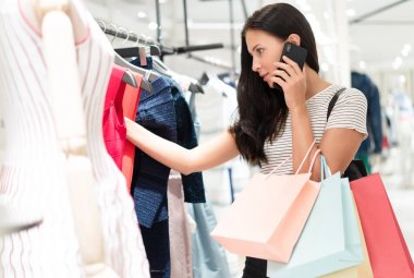 Beautiful woman shopping trendy clothes and talking on a mobile 