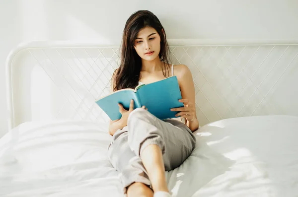 Портрет красивой молодой азиатки, читающей книгу в солнечный день — стоковое фото