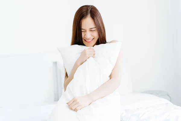 Portret uśmiechniętej pięknej młodej azjatyckiej kobiety trzymającą poduszkę — Zdjęcie stockowe