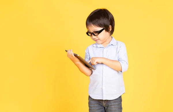 Portré egy aranyos ázsiai kisfiú szemüvegek segítségével tabletta — Stock Fotó
