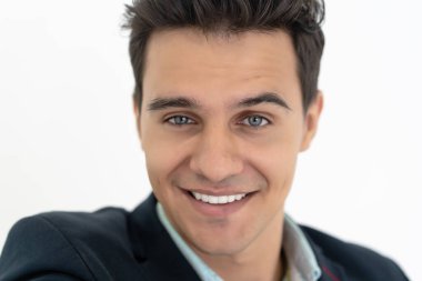 Yakışıklı adamın dostane gülümseyen ve izole beyaz arka plandaki kameraya bakan portresini yakından çek. İnsanlar yaşam tarzı konsepti.