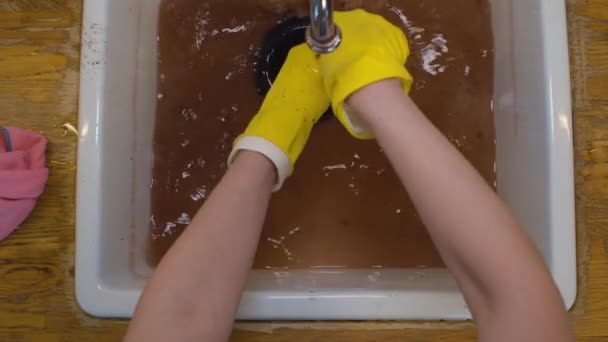 Kvinnliga händer rengöra en blockering i ett diskbänk — Stockvideo