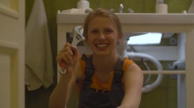 İngiliz anahtarıyla poz veren işçi kadın.