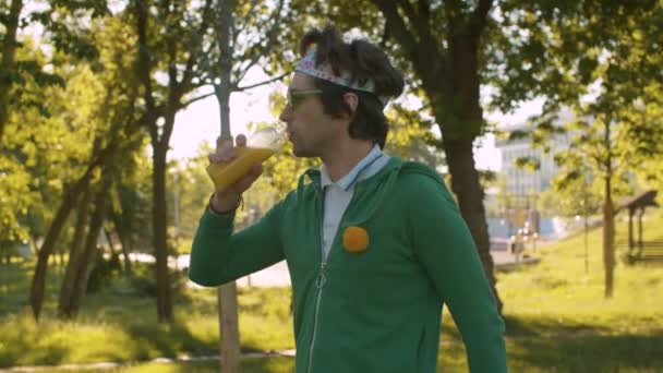 Αστεία φρικιό στο πάρκο πίνοντας χυμό — Αρχείο Βίντεο