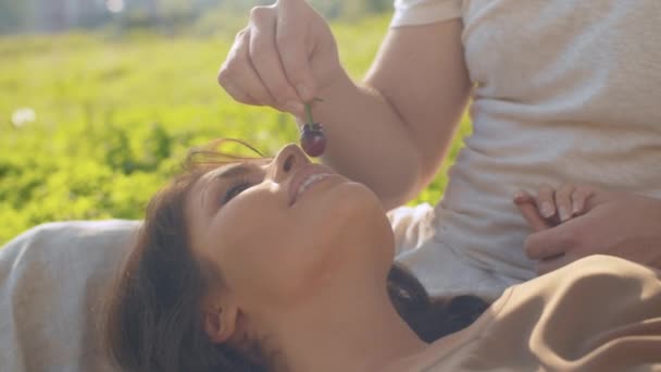 Retrato de una mujer acostada sobre rodillas masculinas — Vídeos de Stock