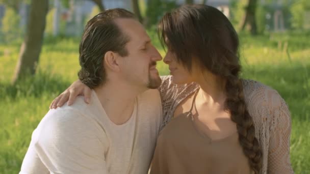 Портреты красивой пары, целующейся в парке — стоковое видео