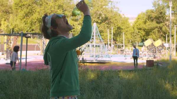 Vicces Őrült Férfi Parkban Ivóvizet Iszik Egy Üvegből Spriccel Vizet — Stock Fotó