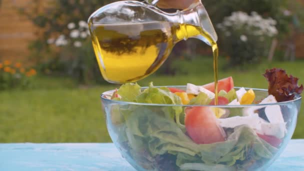 Оливкова олія вливається в миску з салатом — стокове відео