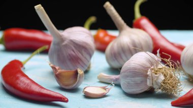 Masanın üzerine taze çiğ sarımsak ve baharatlı biber koy.