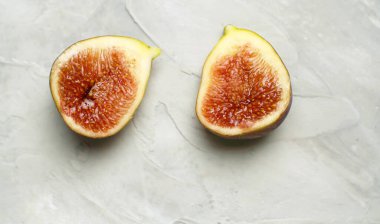 Makro beyaz arka planda masanın üzerine olgun incir parçaları serpiştirdi. Sağlıklı taze gıda konsepti