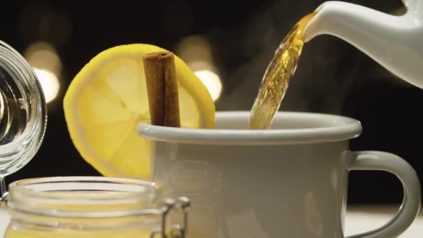 Thé versé dans une tasse avec du citron et de la cannelle — Video