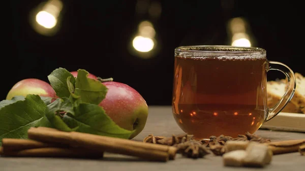 Чай в стеклянной кружке, яблоки и специи — стоковое фото