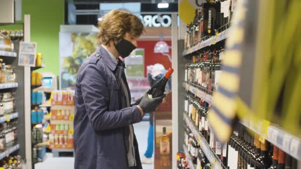 Hombre guapo eligiendo vino en el supermercado — Vídeos de Stock