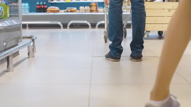Pernas de um homem de pé no supermercado — Vídeo de Stock