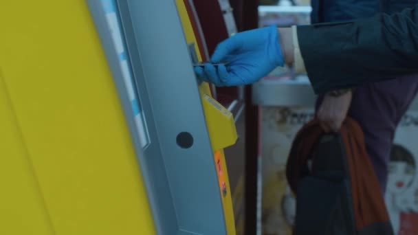 Mano femenina con guantes protectores insertando una tarjeta en un cajero automático — Vídeo de stock