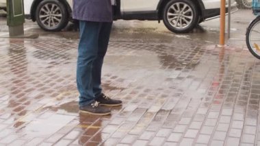 Kare çizgisinde kuyrukta bekleyen bir adam