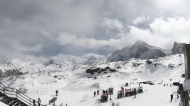 Zaman aşımı - Matterhorn Buzul Cenneti kayak merkezinden geçen kayakçılar Zermatt, İsviçre, Avrupa 'daki kış manzarasının arka planında güzel dağ zirveleri ile