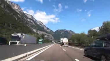 Arka planda güzel dağ zirveleri, Dolomitler, İtalya ve Avrupa 'nın bulunduğu bir italyan otoyolunda trafiğe çıkan hiperlapse