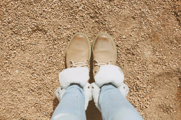 红色冬季靴 背景为褐色沙石 — 图库照片