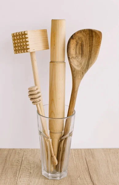 Wooden kitchen items in a glass on a white background.Natural materials and eco-friendly home