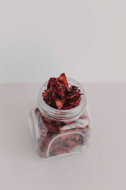 Beyaz arka planda otlu pancar kökü parçalarıyla şeffaf bir kavanoz. Sağlıklı ev yapımı atıştırmalıklar